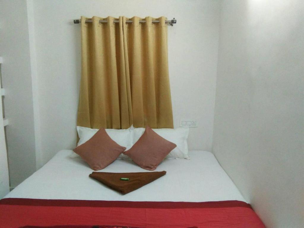a small bedroom with a bed with a curtain at Sukun Guest House in Siliguri