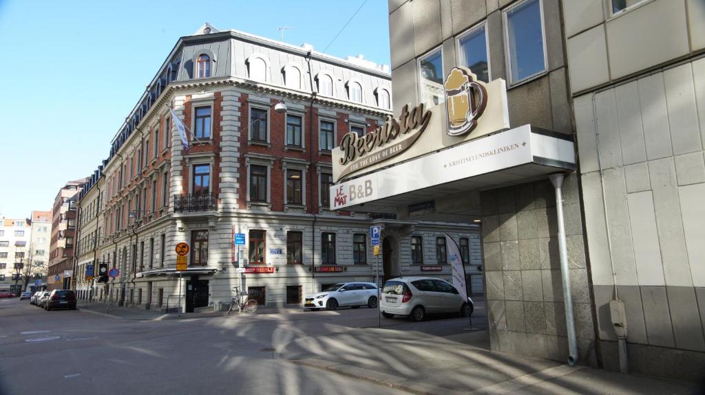 a city street with cars parked in front of a building at Le Mat B&B Göteborg City in Gothenburg