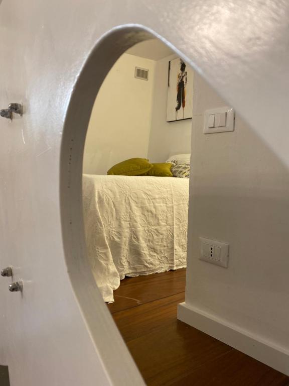 a bedroom with a bed through a circular mirror at La Verde di Vernazza - Art Studio - AC&WiFi - Vernazzarentals in Vernazza