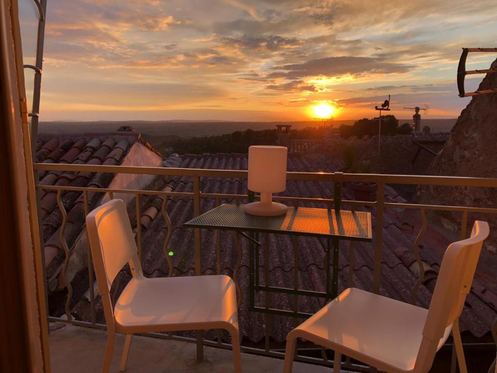 a table and chairs on a balcony with a sunset at Maison Provence à Baudinard-sur-Verdon in Baudinard