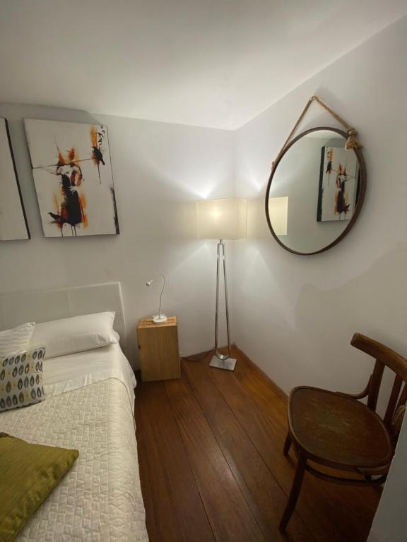a bedroom with a bed and a mirror and a chair at La Verde di Vernazza - Art Studio - AC&WiFi - Vernazzarentals in Vernazza