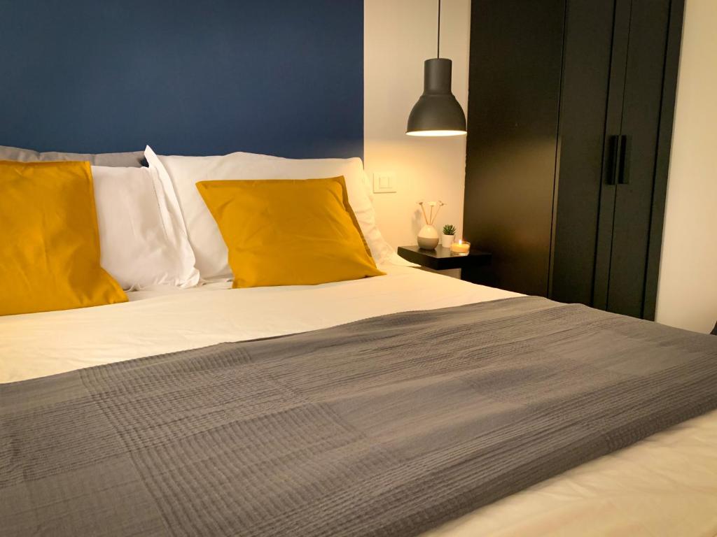 a bedroom with a large bed with yellow pillows at Galè Apartment in Bologna