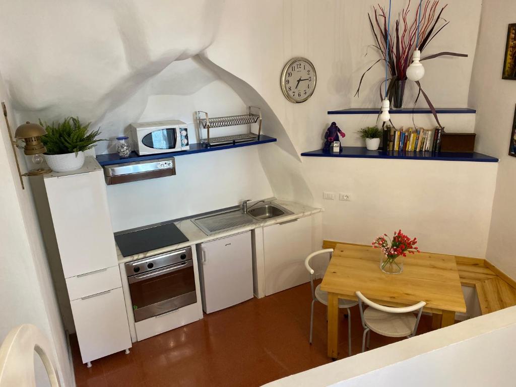 a small kitchen with a wooden table and a dining room at La Verde di Vernazza - Art Studio - AC&WiFi - Vernazzarentals in Vernazza