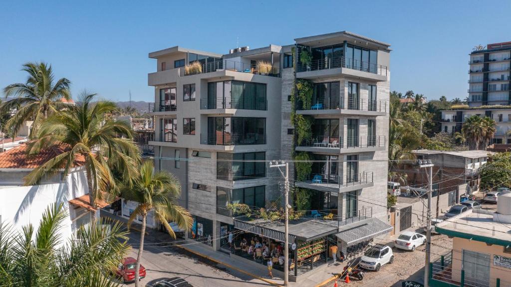 un edificio de apartamentos en una calle de la ciudad con palmeras en Nereidas Lofts, en Bucerías