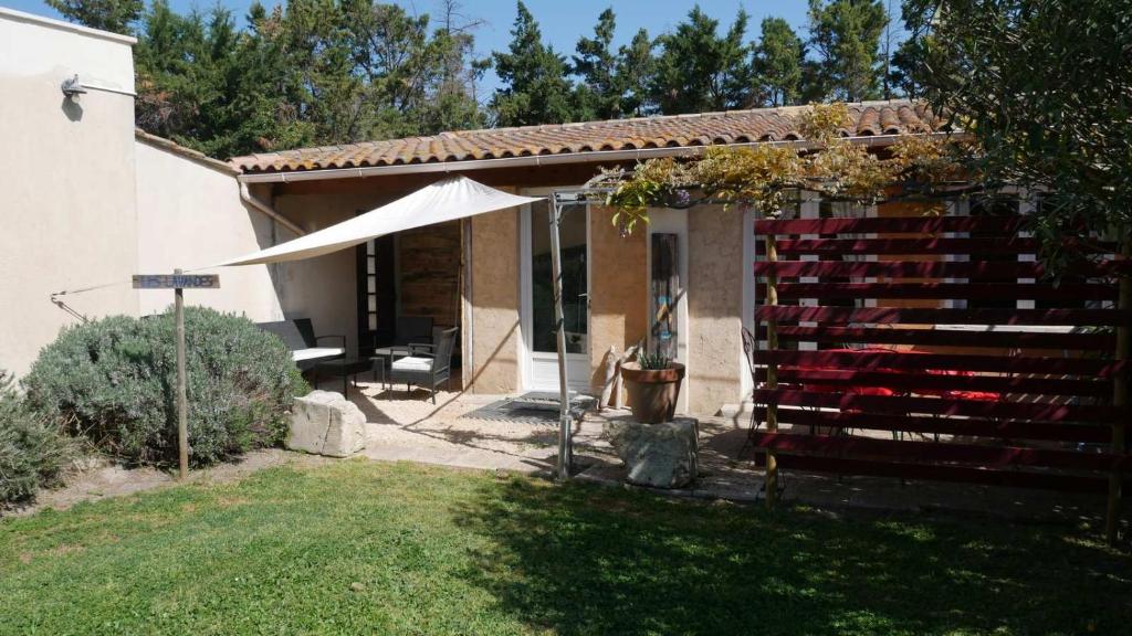 タラスコンにあるMas Maurane - Les Lavandes aux portes d'ARLESの庭の白傘とベンチ付き家