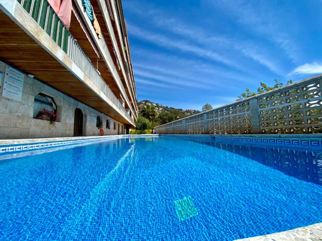 una gran piscina junto a un edificio en Apartamento con vistas a Mar en Lloret de Mar, en Lloret de Mar