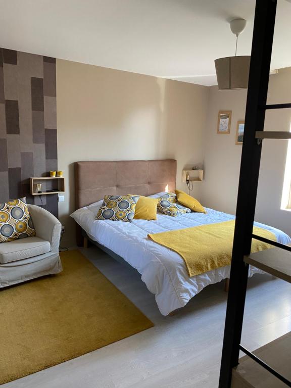 1 dormitorio con 1 cama grande y 1 silla en Au Rythme des Vagues en Saint-Aubin-sur-Mer