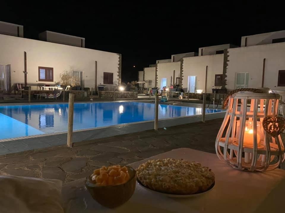 uma mesa com uma tigela de comida ao lado de uma piscina em Residence Amalia em Pantelleria