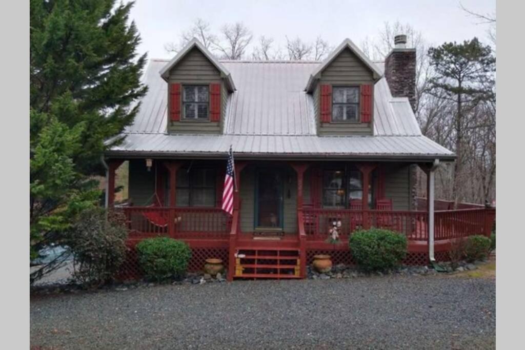 una casa roja con una bandera delante de ella en Eagle Mountain River Retreat en Ellijay