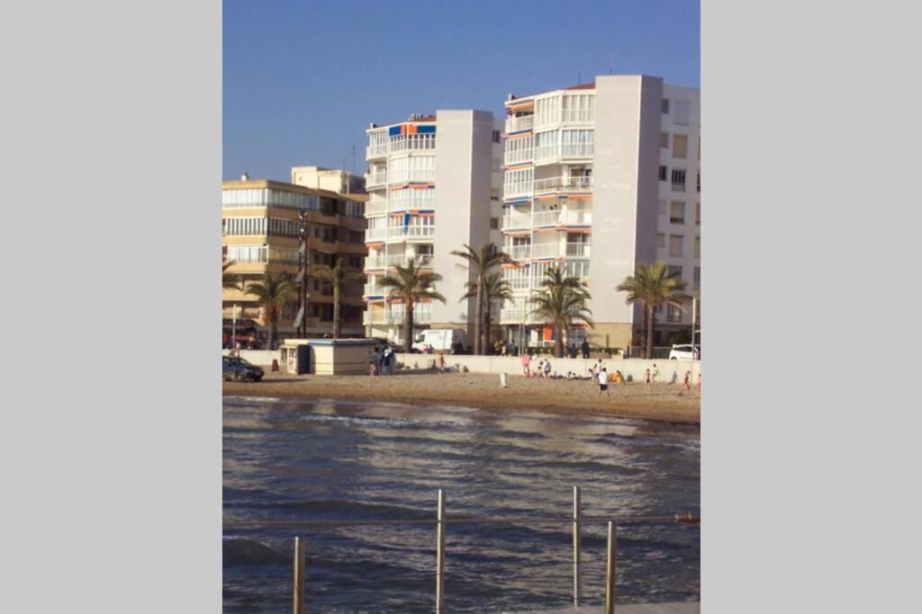 vistas a una playa con edificios y palmeras en Bello Horizonte, en Salou