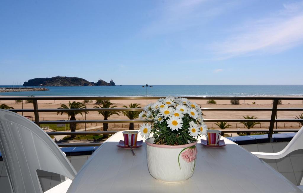 una mesa con una maceta de flores en la playa en Catalonia 3-6, en L'Estartit