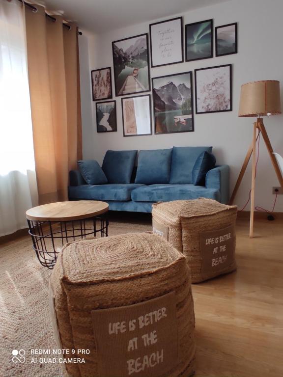 Malpica Nordic Home في مالبيسا: غرفة معيشة مع أريكة زرقاء وطاولة