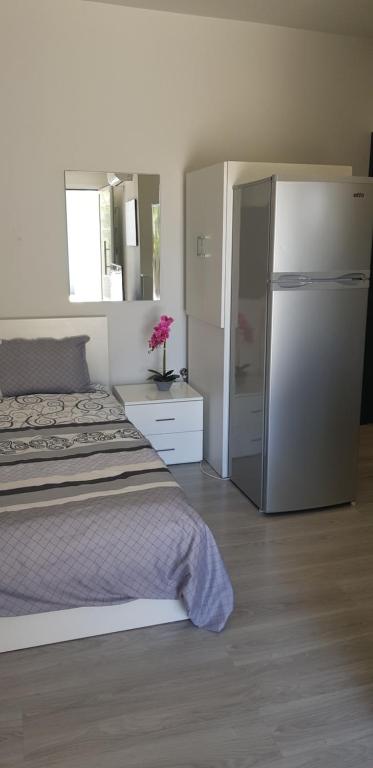 1 dormitorio con 1 cama y nevera en Studio Anastasia en Limassol