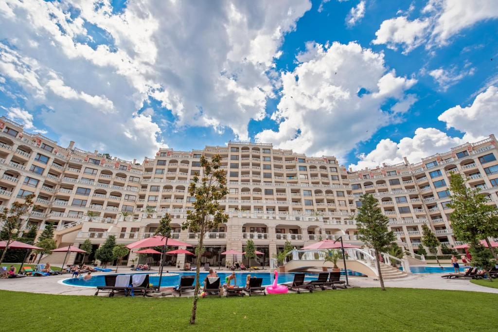 a large resort building with a large pool and chairs at Summertime in Varna South Bay Beach Residence in Varna City