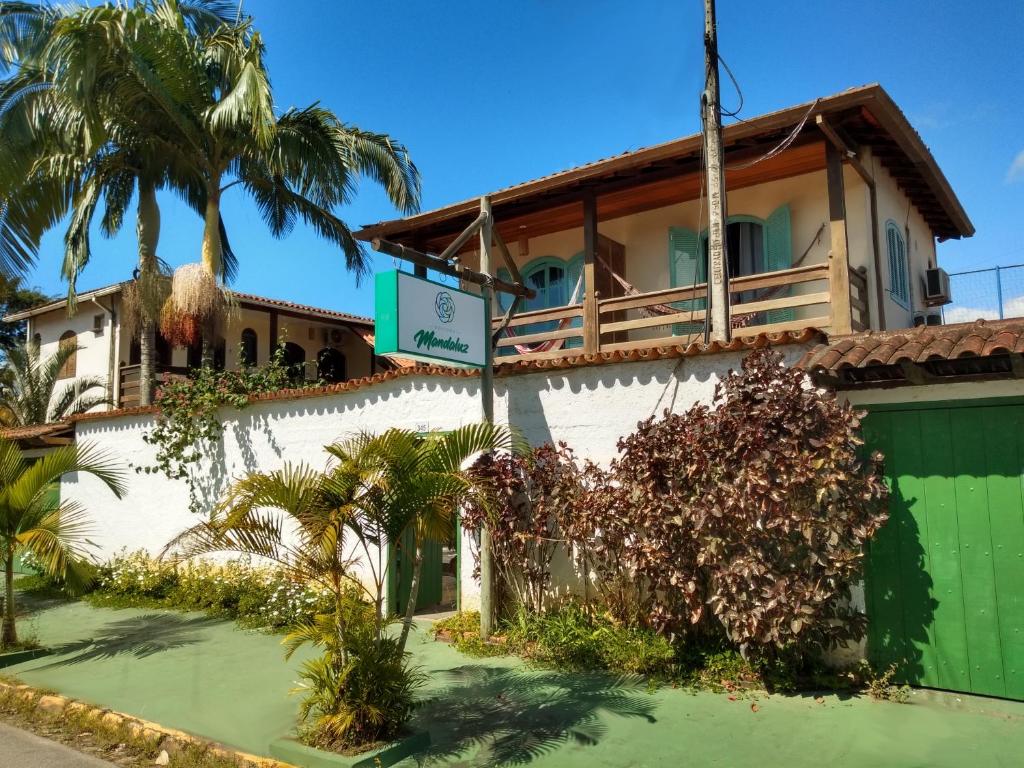 uma casa com um portão verde e palmeiras em Pousada Mandaluz em Paraty