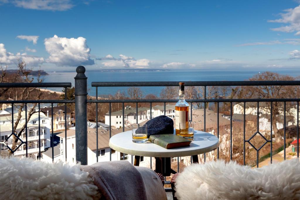 a bottle of wine sitting on a table on a balcony at Vju Hotel Rügen in Göhren