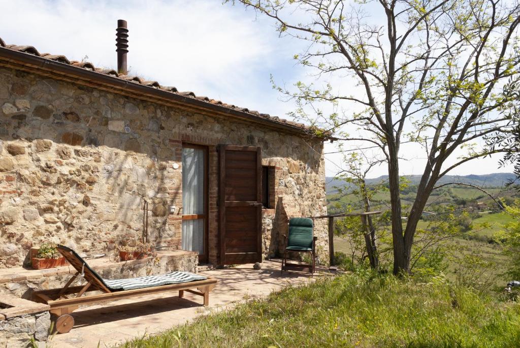 a stone house with a wooden door and a bench at La Rocca delle Pigne in Cana
