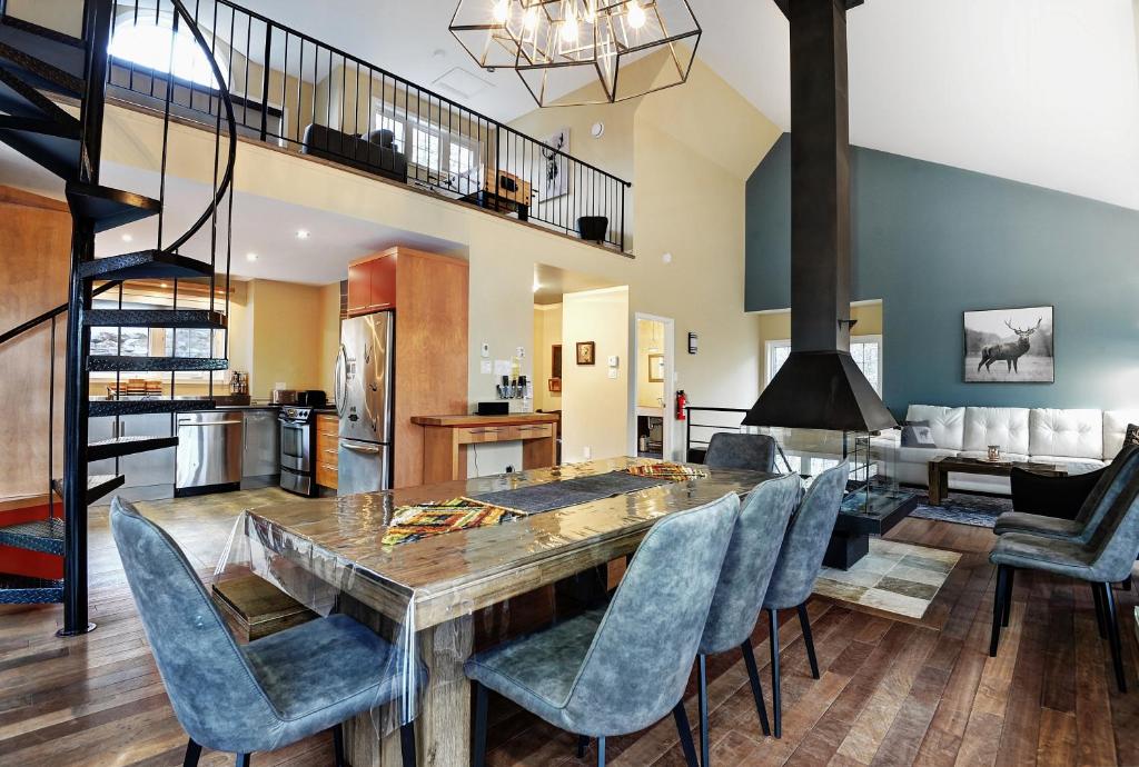 a kitchen and dining room with a wooden table and chairs at Chalets Alpins- 45 Chemin des Skieurs in Stoneham