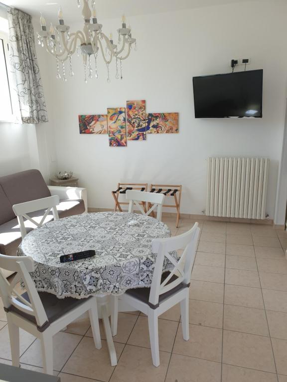 uma sala de jantar com mesa e cadeiras e uma televisão em Casa Trilli em Grottammare