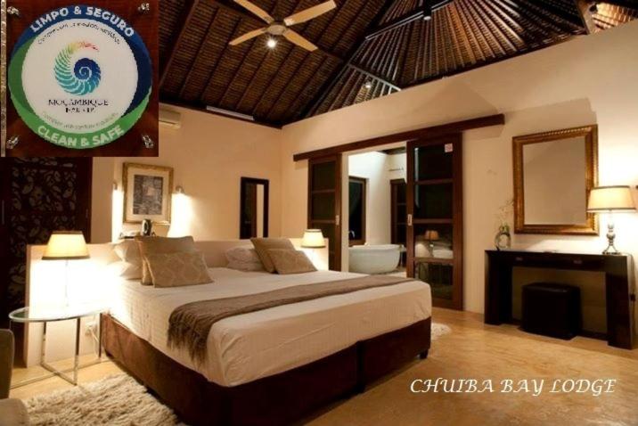 Chuiba Bay lodge في جزيرة بمبا: غرفة نوم بسرير وعلامة على الحائط