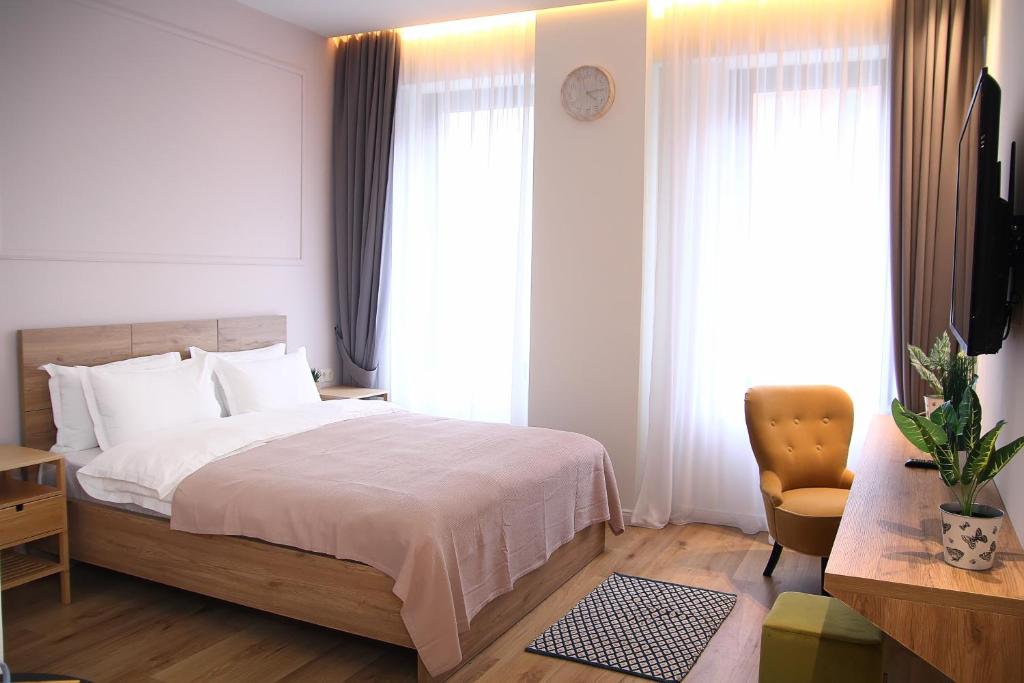 - une chambre avec un lit, une chaise et des fenêtres dans l'établissement Parilament on Rustaveli 4 rooms, à Tbilissi