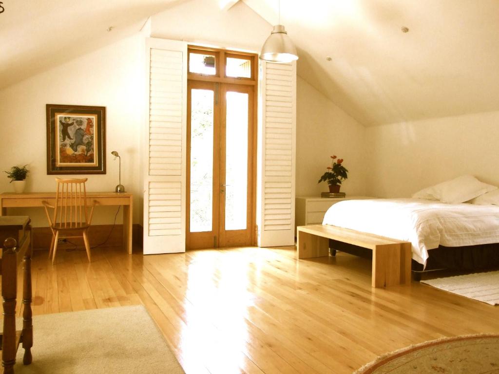 um quarto com uma cama, uma secretária e uma janela em The Loft em Joanesburgo