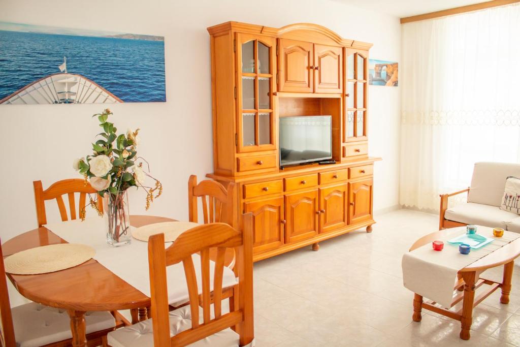 a living room with a dining table and a tv at Apartamento Sol do Coído in Muxia