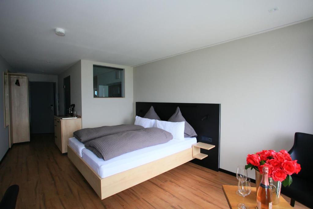 een slaapkamer met een bed en een tafel met bloemen bij Alte Molke Apartment 10 in Meersburg