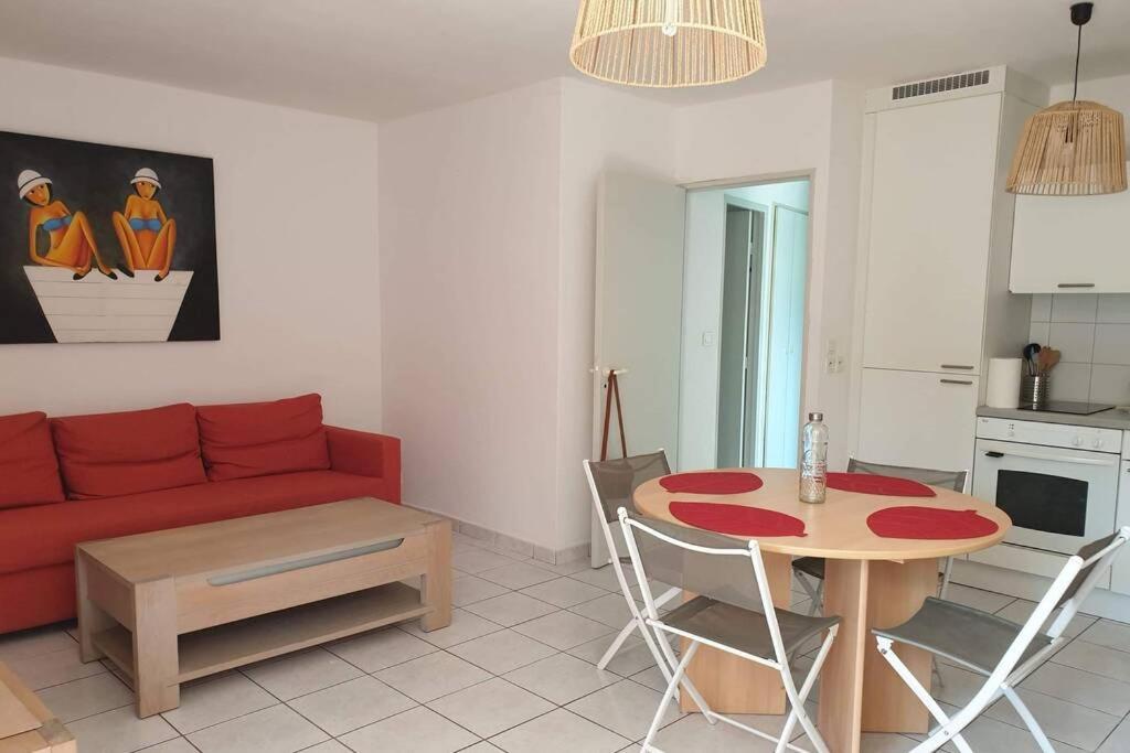 sala de estar con sofá rojo y mesa en Appartement fonctionnel hauteurs de Collioure, en Collioure