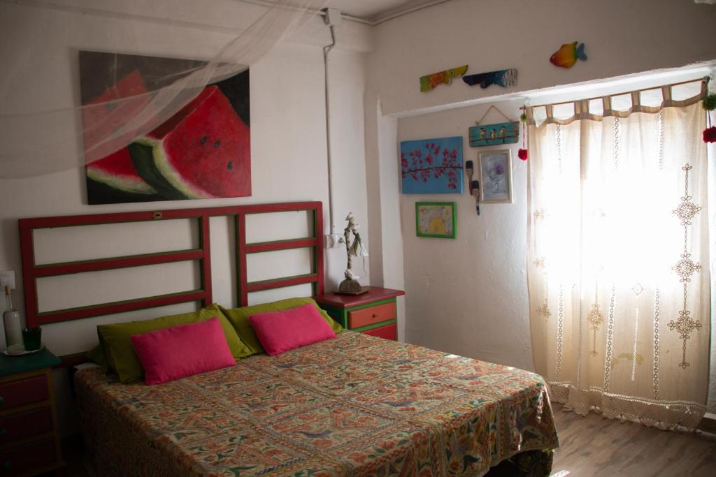 a bedroom with a bed with two pink pillows at El Carmen in Ribera Alta