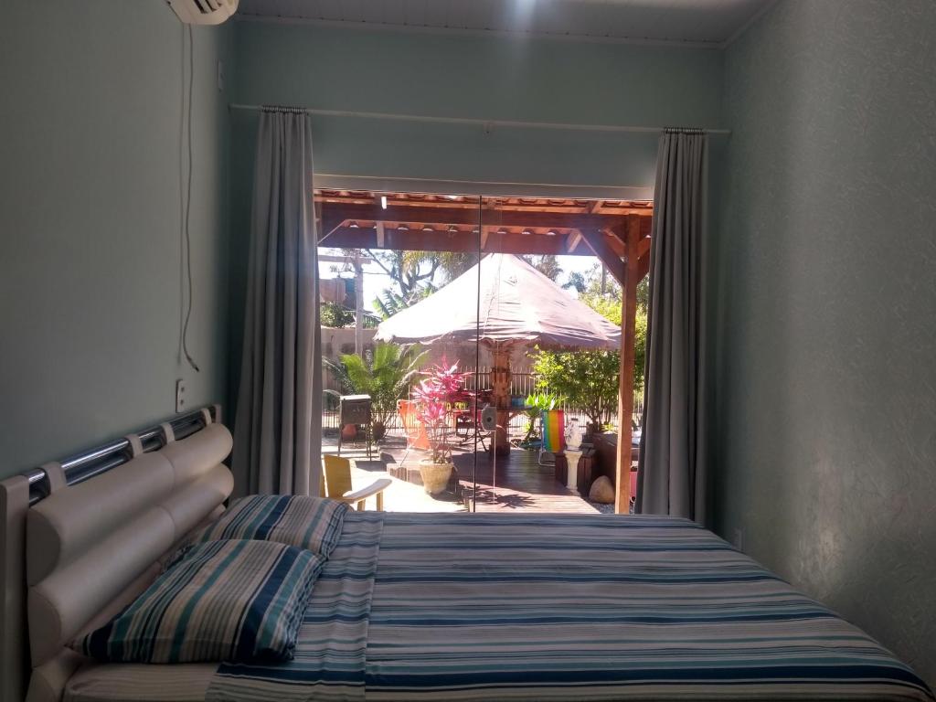 1 dormitorio con cama y vistas a un patio en Cantinho da tia Sandra Suite azul en São Francisco do Sul