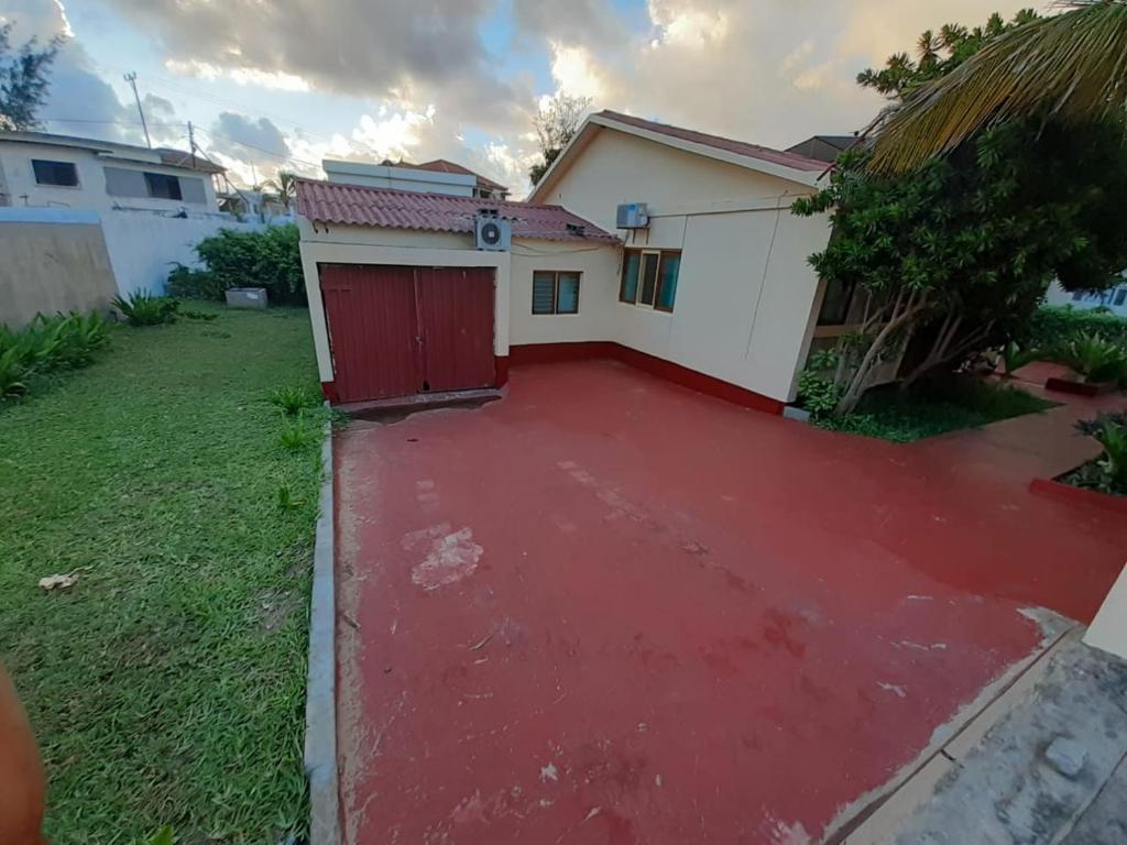 a red driveway in front of a house at Casa Caramba in Praia do Tofo