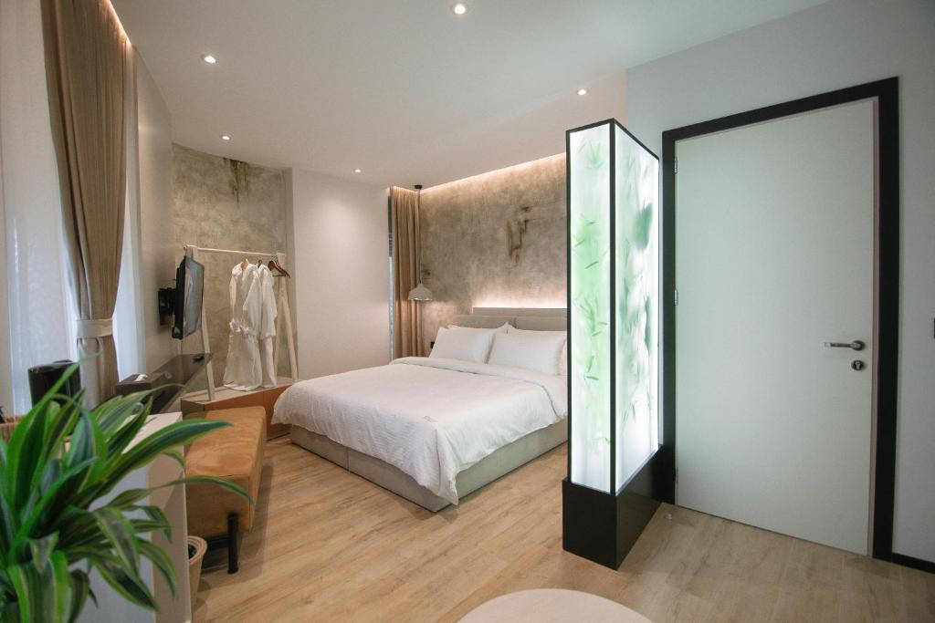 - une chambre avec un lit blanc et un grand miroir dans l'établissement Boulevard Boutique Aparthotel, à Korçë