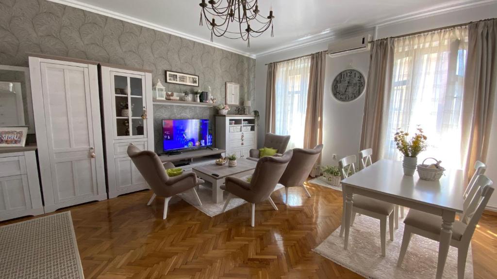 uma sala de estar com uma mesa e cadeiras e uma televisão em Old Town Apartment Ana em Sibiu
