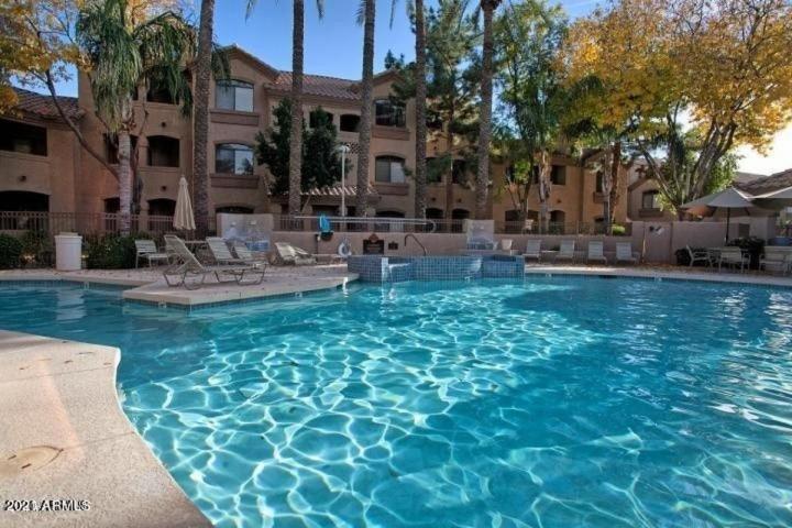 una gran piscina de agua azul frente a un edificio en Villa Captiva condo, en Scottsdale