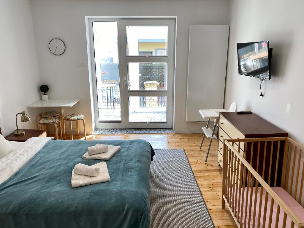 a bedroom with a bed with two towels on it at Apartament na Nadmorskiej in Grzybowo