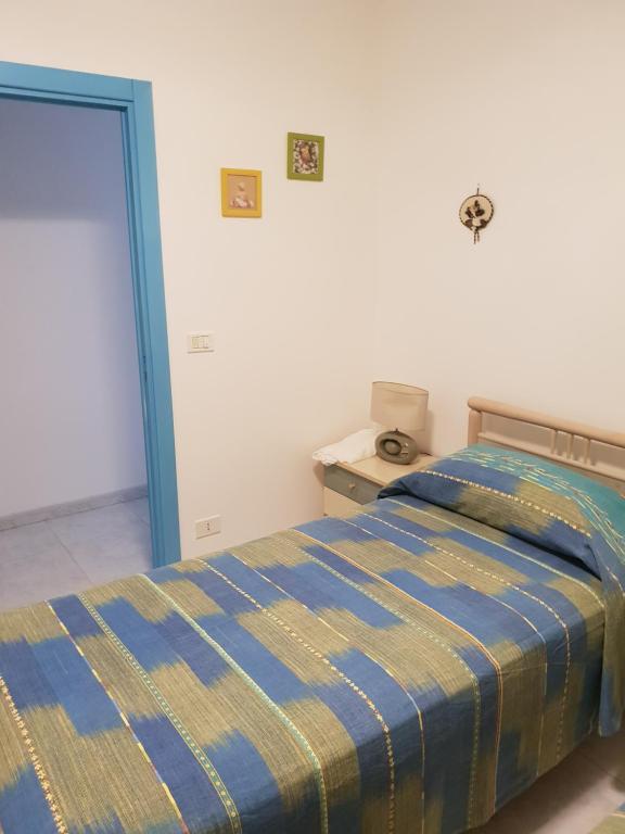 1 dormitorio con 1 cama con edredón azul y amarillo en LA CASA DI NONNA LUCIA en Torre Canne