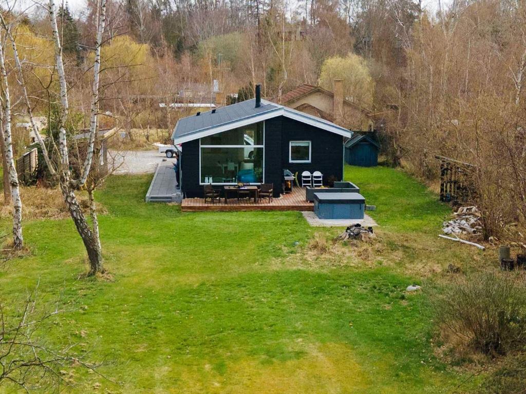 a black house in a field with a yard at 7 person holiday home in Jægerspris-By Traum in Jægerspris