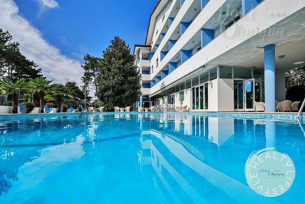 a large swimming pool in front of a building at Hotel Olympia in Lignano Sabbiadoro