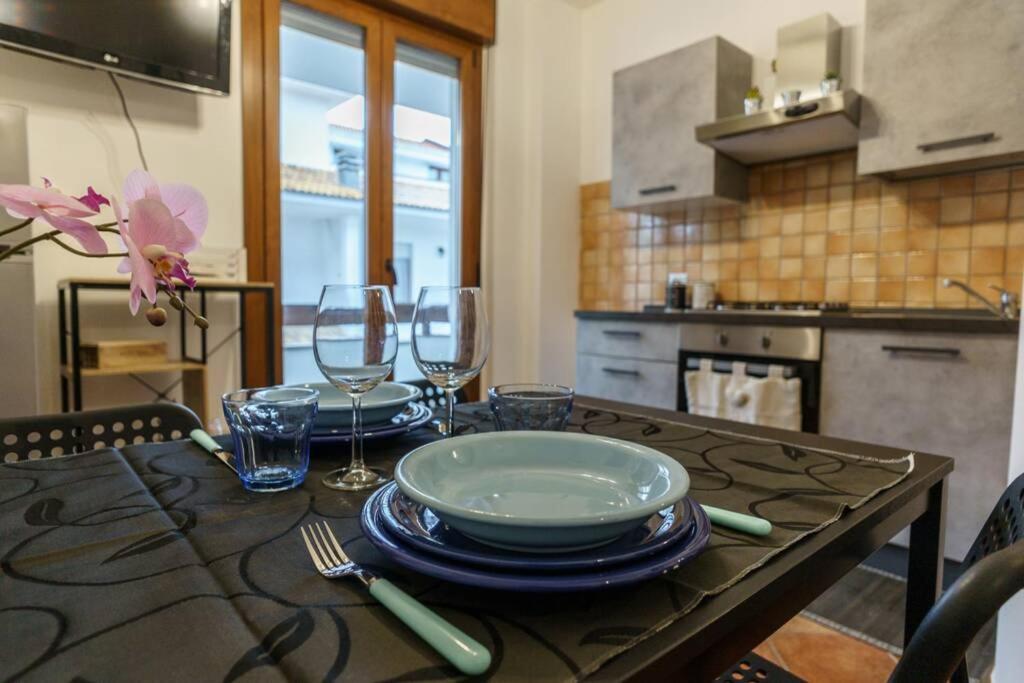 una mesa con platos y copas de vino. en VERY WELL apartment, en Porto Torres