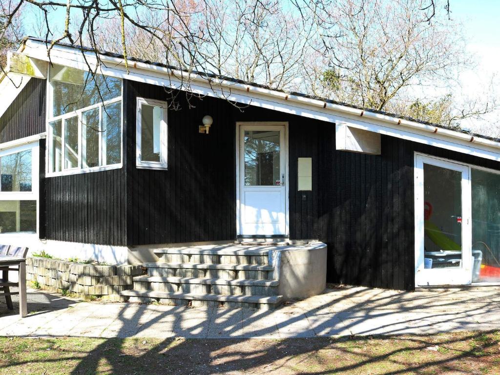 OddeにあるFour-Bedroom Holiday home in Hadsund 4の白い扉とポーチのある黒い家