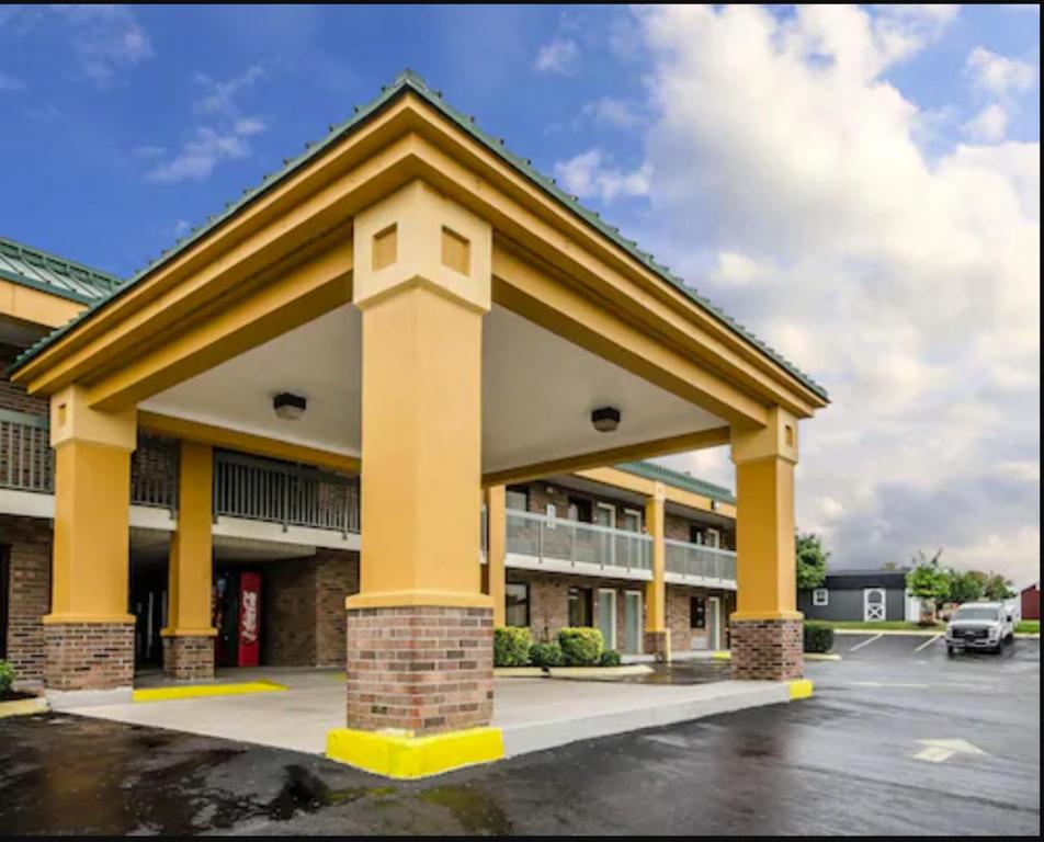 a large building with yellow columns in a parking lot at Quality Inn in Franklin