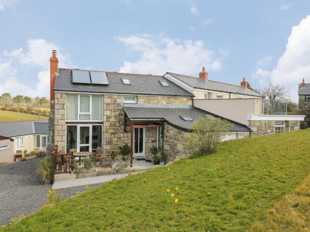 a house with solar panels on top of a hill at Mynheer Farm Barn in Redruth