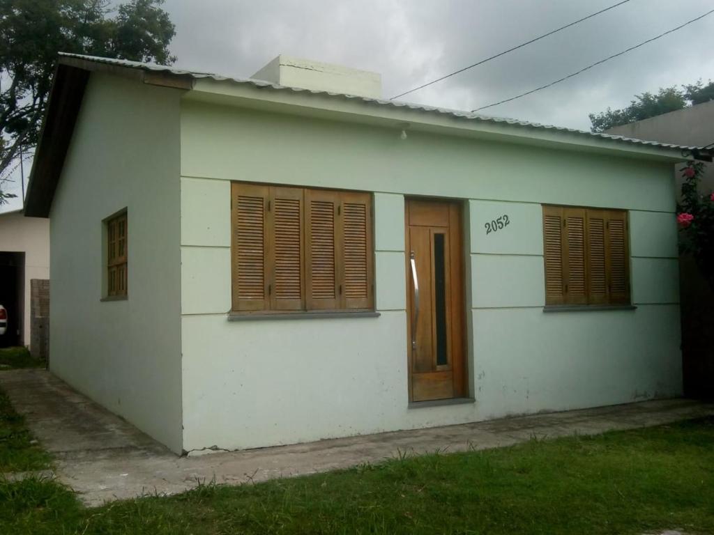 Una casa blanca con persianas marrones. en POUSADA IDEAL, en Uruguaiana