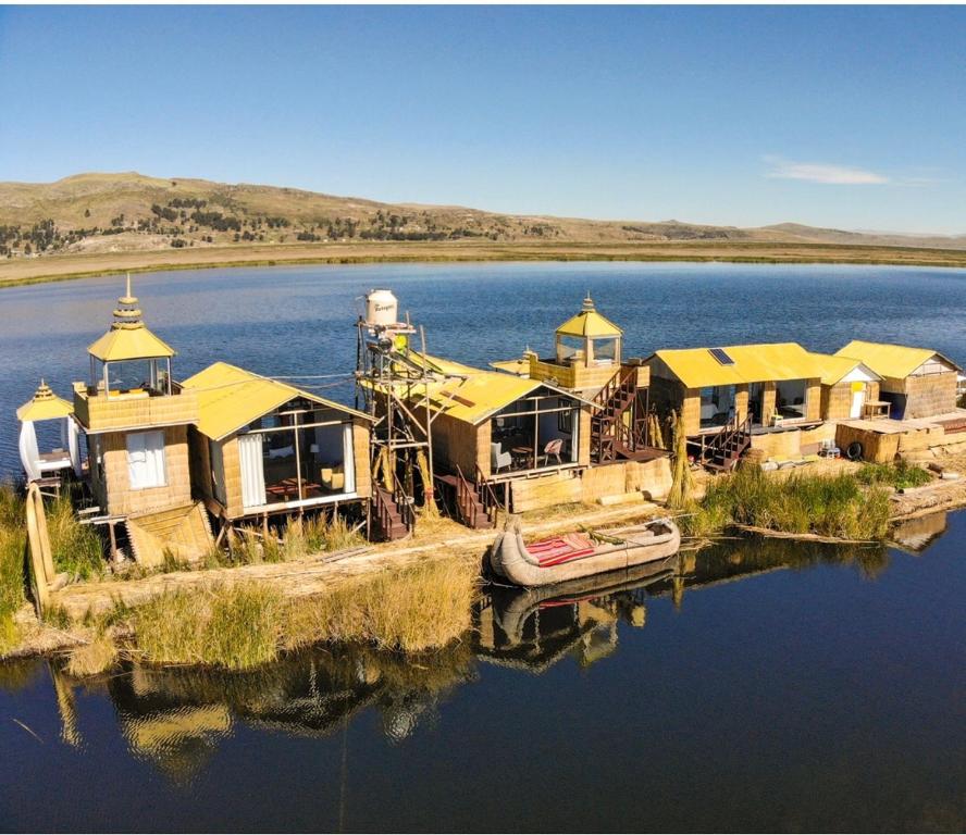 a group of houses on an island in the water at Amalia Titicaca Lodge in Puno