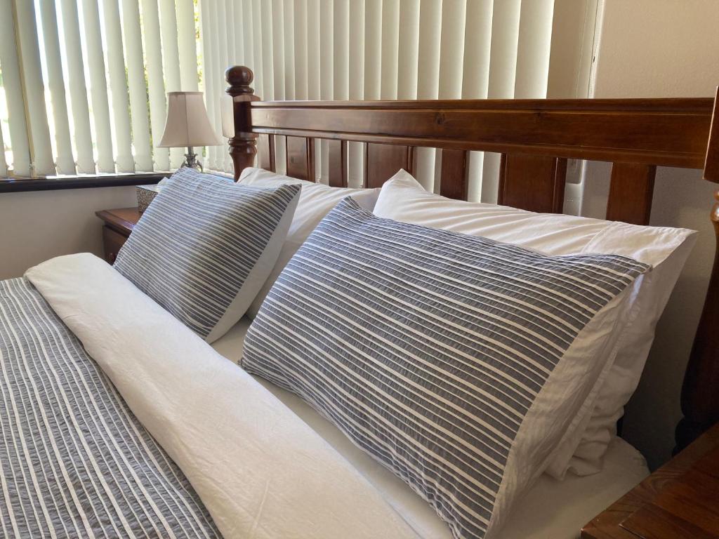 
a bed that has some pillows on it at The Royal Dolphin Bed & Breakfast Safety Bay in Rockingham
