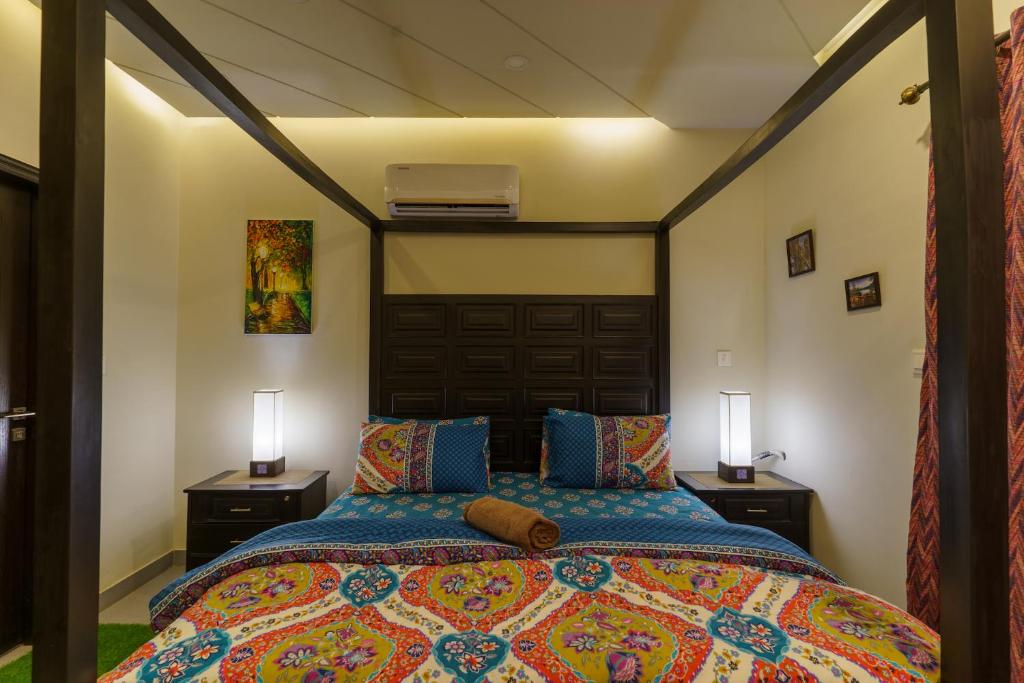 a bedroom with a bed with two night stands and two lamps at Serenity Corner in Islamabad