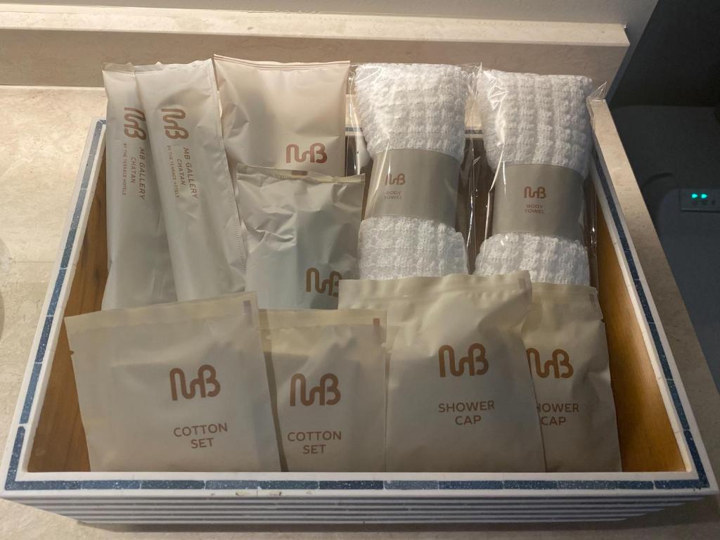 a box filled with white packets of towels at MB GALLERY CHATAN by THE TERRACE HOTELS in Chatan