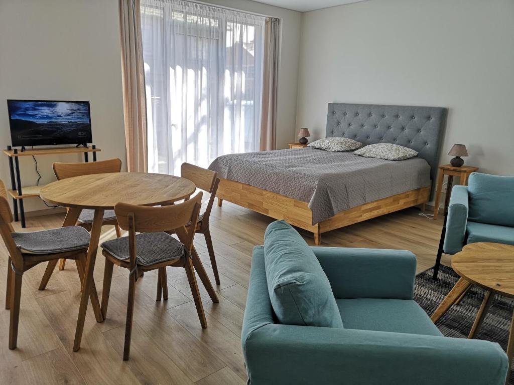 een slaapkamer met een bed en een tafel en stoelen bij Centro apartamentai II in Birštonas