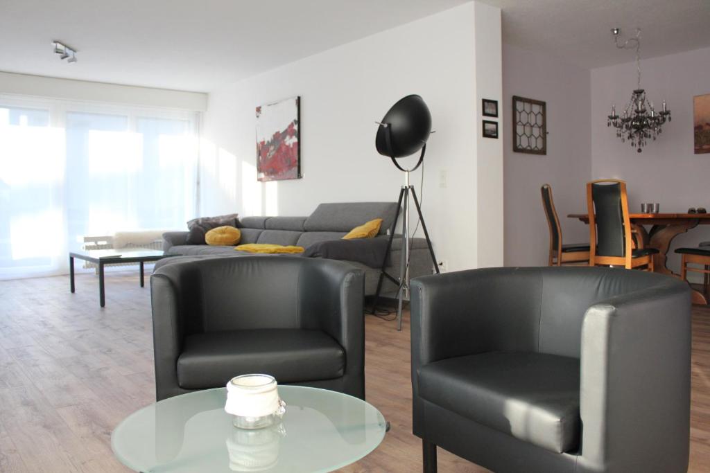 sala de estar con 2 sillas y sofá en Dorfklatsch Ferienwohnung, en Emmetten